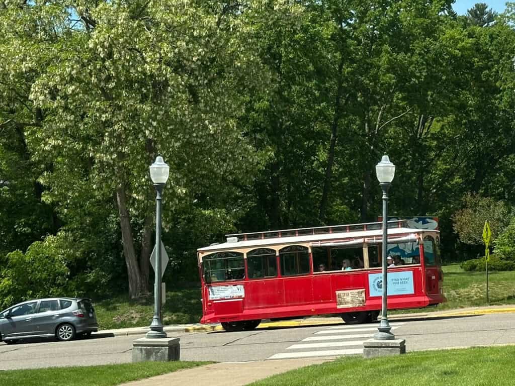 stillwater trolley tour passing by the Stillwater Public Library on a sunny afternoon
