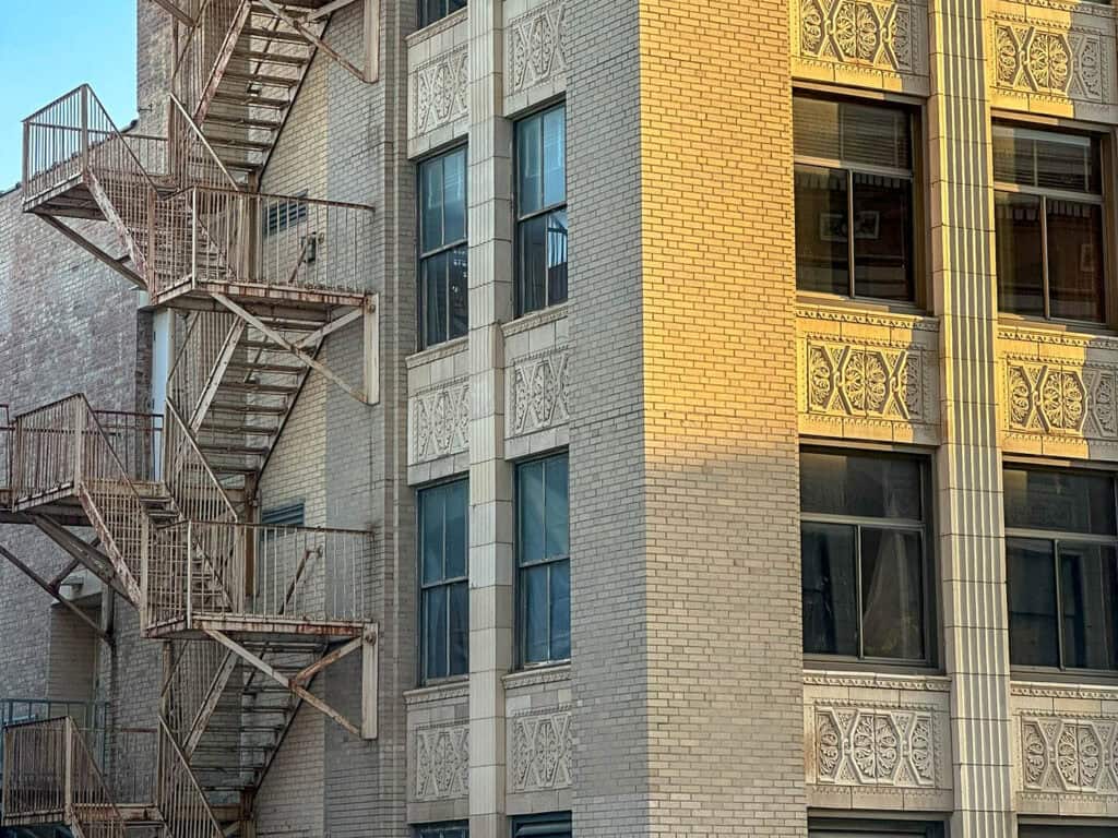 historic art deco building in downtown sioux city, iowa with light brick facade, decorative stone panels, and rows of large windows in golden evening light