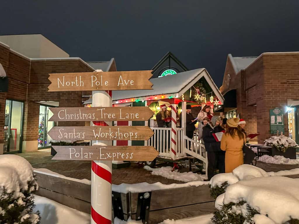 carolers outside santa at the north pole in downtown crystal lake