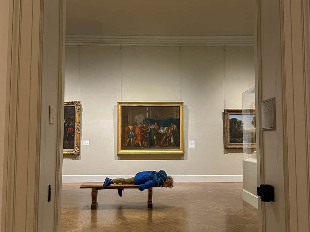 kid on a bench in a room full of art at Mia